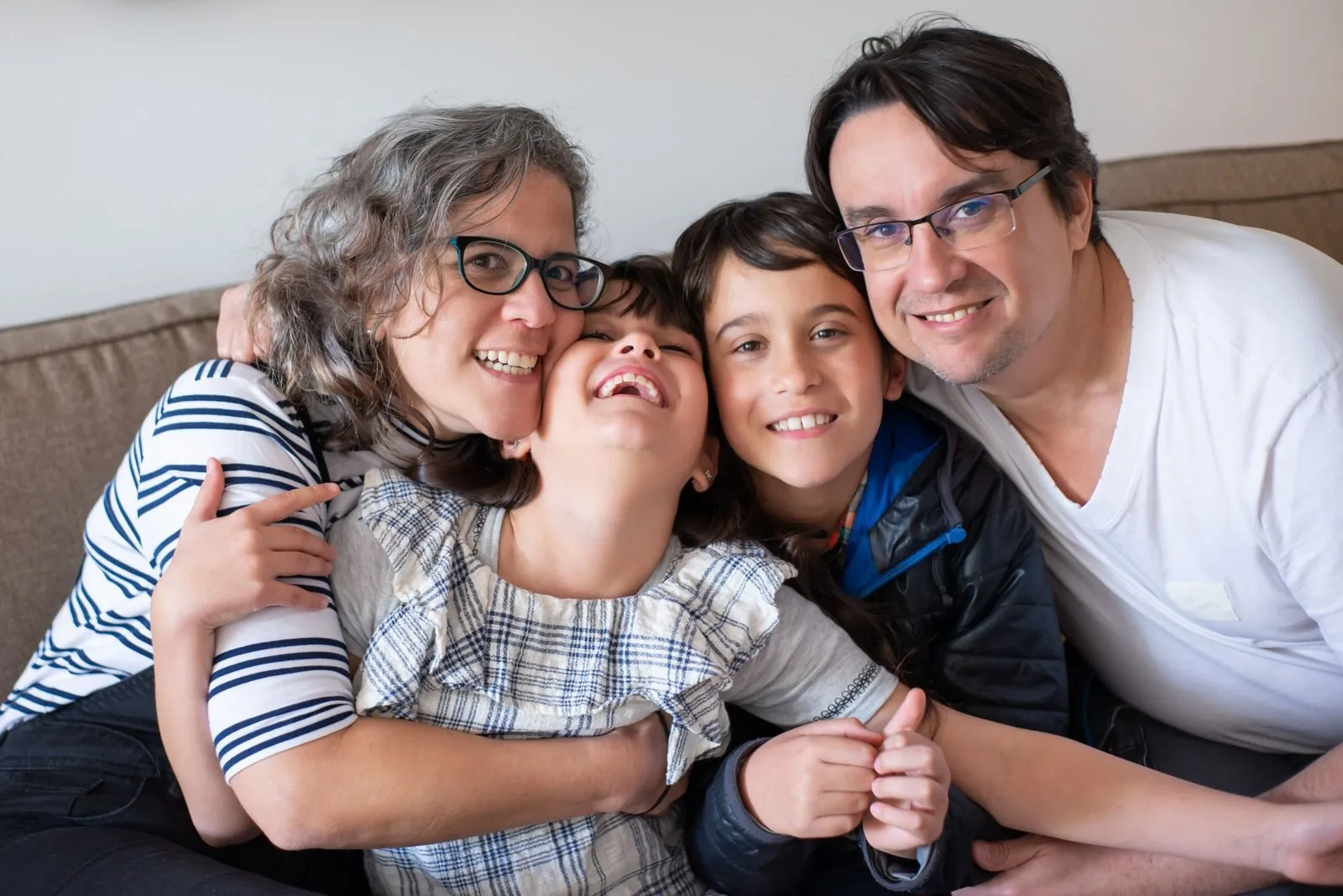 Famiglia sorridente sul divano di casa
