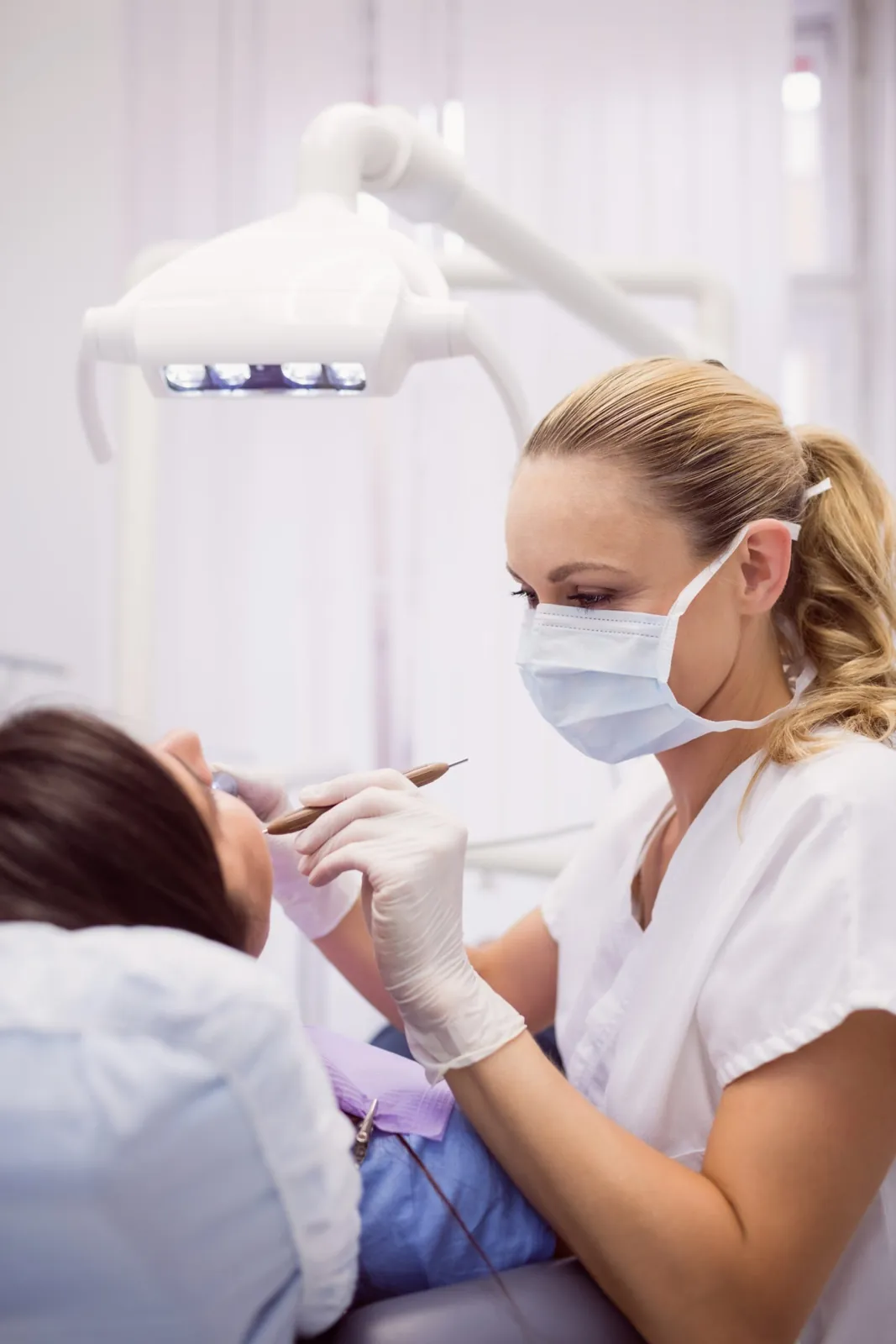 Dentista al lavoro con una paziente sulla poltrona